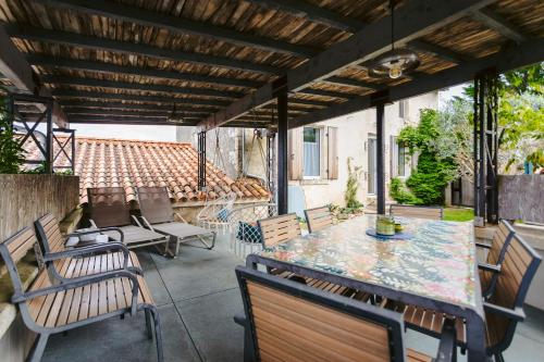 d'une terrasse avec une table et des chaises ainsi qu'un toit. dans l'établissement Gite les 3 piliers, à Pissotte