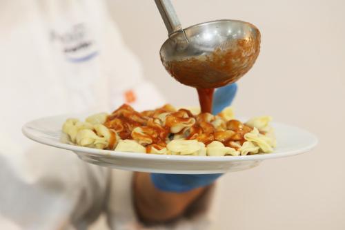 a person holding a plate of food with a spoon at Hotel-Apartamentos Andorra in Playa de las Americas