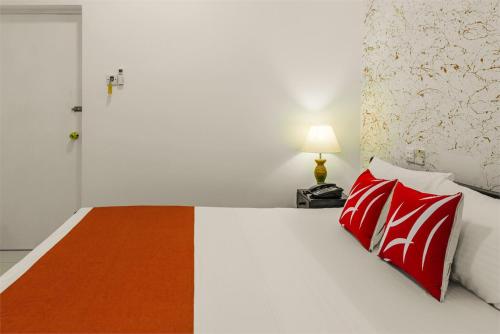 a bedroom with a bed with red pillows and a lamp at Beverly Hills Hotel in Mount Lavinia
