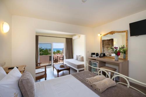 Pokój hotelowy z łóżkiem i lustrem w obiekcie Orpheas Resort Hotel (Adults Only) w mieście Georgioupolis