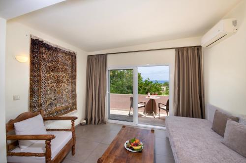 a living room with a couch and a table at Orpheas Resort Hotel (Adults Only) in Georgioupolis