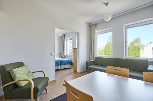 ein Wohnzimmer mit einem Sofa und einem Tisch in der Unterkunft Töölö Towers in Helsinki