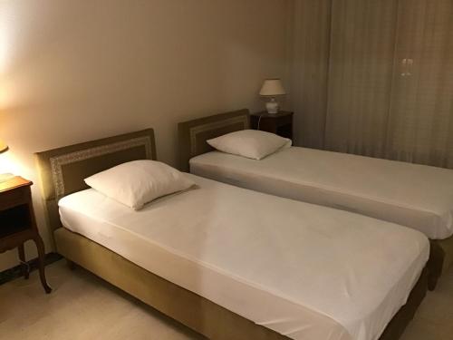 deux lits dans une chambre d'hôtel avec des draps blancs dans l'établissement FOCH - 100 M DE LA MER - 500 M CENTRE VILLE, à Antibes