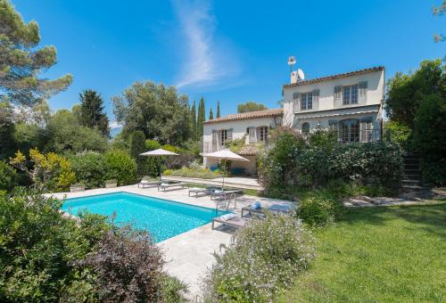 une maison avec une piscine dans une cour dans l'établissement La Clairiere, à Valbonne