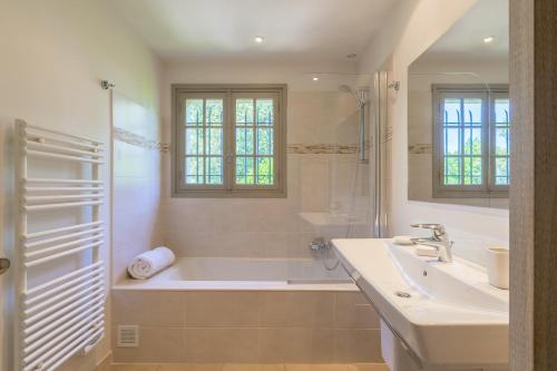 une salle de bain avec une baignoire, un lavabo et une douche dans l'établissement La Clairiere, à Valbonne