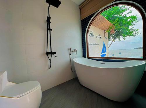 eine Badewanne im Bad mit Fenster in der Unterkunft BE Villa - Phu Quy Island in Cu Lao Thu
