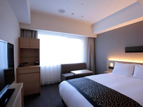 um quarto de hotel com uma cama e uma televisão em Hotel Intergate Kyoto Shijo Shinmachi em Quioto