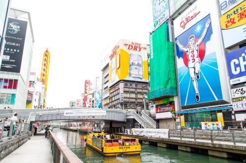 a yellow boat in a river in a city at Osaka Tokyu REI Hotel in Osaka