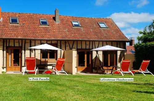 a group of chairs and umbrellas in front of a house at La Fermette des Ramolleux in Crécy-en-Ponthieu