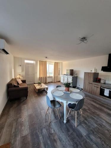 un salon avec une table, des chaises et un canapé dans l'établissement T2 plain-pied, en centre-ville, à Buzançais