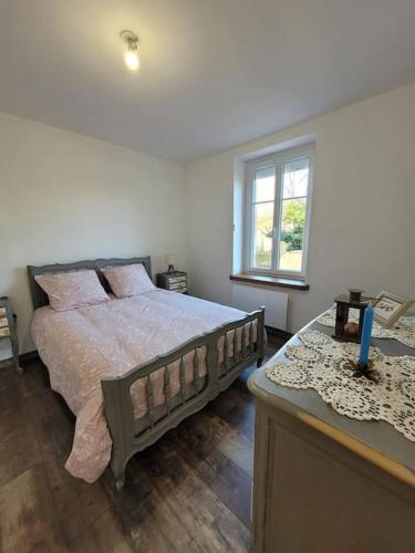 une chambre avec un grand lit et une fenêtre dans l'établissement T2 plain-pied, en centre-ville, à Buzançais