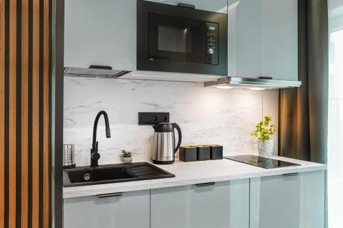 a kitchen with a sink and a microwave at Stylowe Apartamenty w Centrum in Wrocław