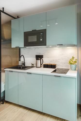 a kitchen with blue cabinets and a sink at Stylowe Apartamenty w Centrum in Wrocław