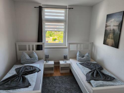 two beds in a room with a window at Andrews Ferienwohnungen in Tangermünde