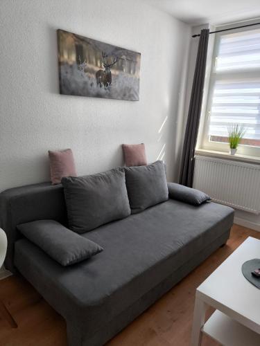 a grey couch in a living room with a window at Andrews Ferienwohnungen in Tangermünde