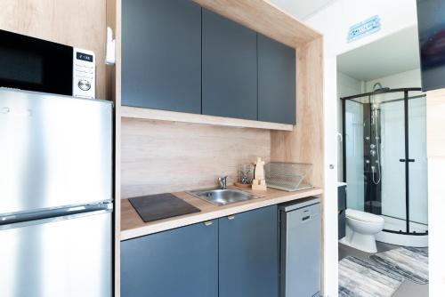 a kitchen with a sink and a refrigerator at Mobile home Mia & Roko - Beach Porat, Drage in Drage