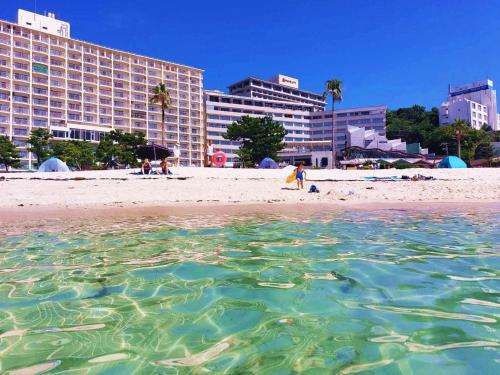 a view of a beach with a hotel in the background at Hotel Sanrakuso in Shirahama
