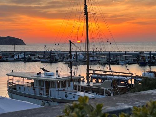 ein Boot, das bei Sonnenuntergang am Yachthafen angedockt ist in der Unterkunft First row to the sea - Maremi Izola Apartment terrace in Izola