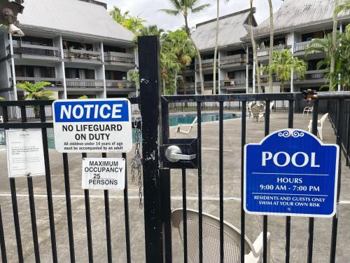 a fence with signs on it with a pool at Studio in Hilo Center with Pool and Lake Views in Hilo