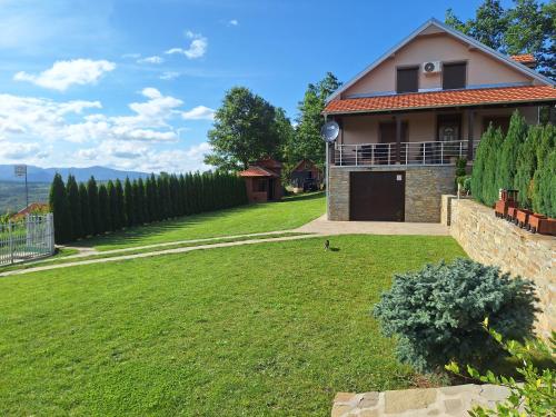 una casa con un gran patio con césped en Apartmani Milosavljević, en Kuršumlija
