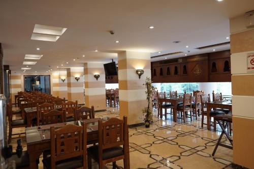 Amon Alexandria في الإسكندرية: غرفة طعام مع طاولات وكراسي في مطعم