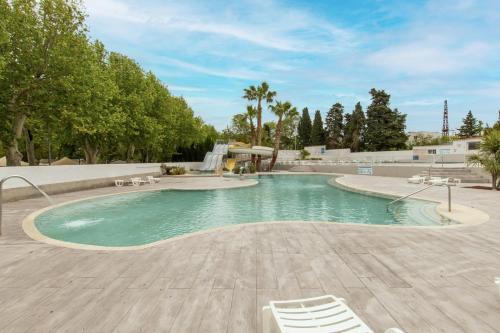 - une piscine avec 2 chaises et une cascade dans l'établissement Mobil-home Entre Terre & Mer, à Agde