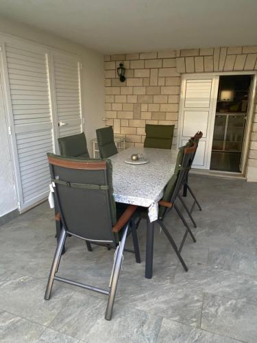 een tafel en stoelen op een patio bij Red Hill Beach House - stunning 3-story residence in Zaboric