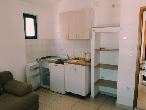 uma pequena cozinha com um lavatório e um balcão em Apartments Andrea em Drvenik