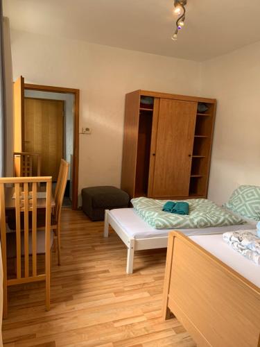 ein kleines Zimmer mit 2 Betten und einem Stuhl in der Unterkunft Erlangen City-Zentral-Garten-30qm in Erlangen