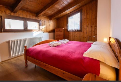 1 dormitorio con 1 cama grande con manta roja en La Marmote Albergo Diffuso di Paluzza Clome, en Paluzza