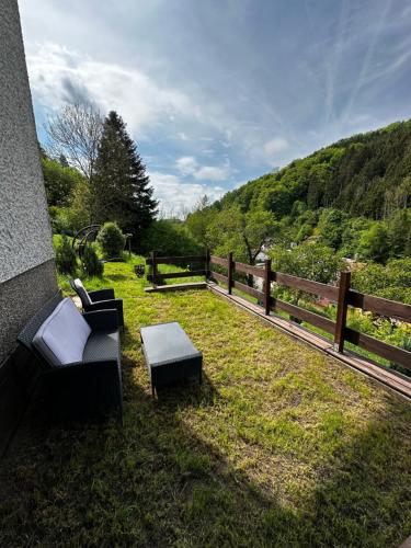 een achtertuin met twee stoelen en een tafel en een hek bij Haus am See in Biersdorf