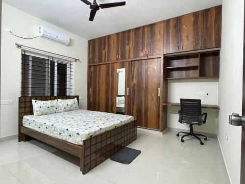 a bedroom with a bed and a chair in it at SSN Home Stays in Bangalore near PLAY Arena in Bangalore