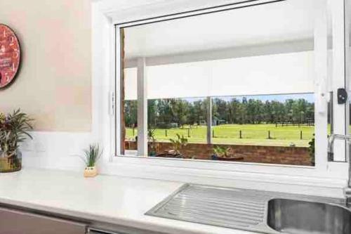 a kitchen counter with a window and a sink at Anna Bay 20 acres luxury farm in Salt Ash