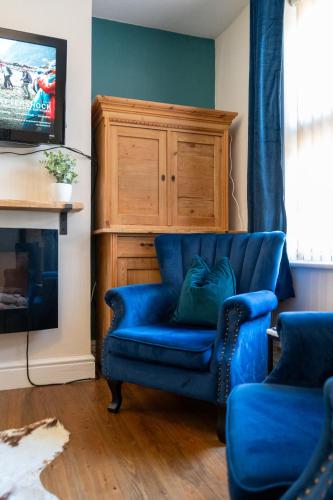 a blue couch in a living room with a tv at The Plumb Townhouse in Warwick Centre in Warwick
