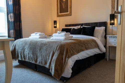 a bedroom with a bed with towels on it at The Plumb Townhouse in Warwick Centre in Warwick