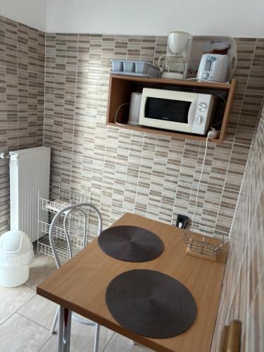 uma cozinha com uma mesa de madeira e um micro-ondas em Afamado apartman Fisli em Hévíz