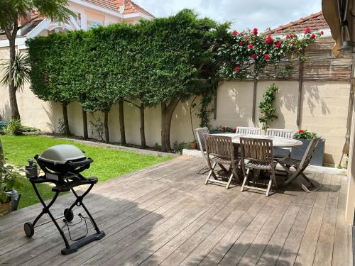 - un barbecue sur une terrasse avec une table et des chaises dans l'établissement Villa Cantemerle, 3 chambres, jardin, à Arcachon