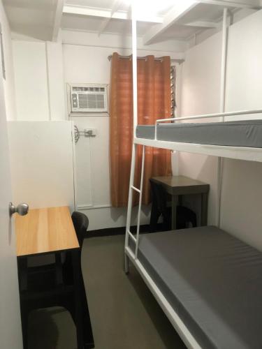 a small room with a bunk bed and a table at Two Hearts Boarding Home in Manila