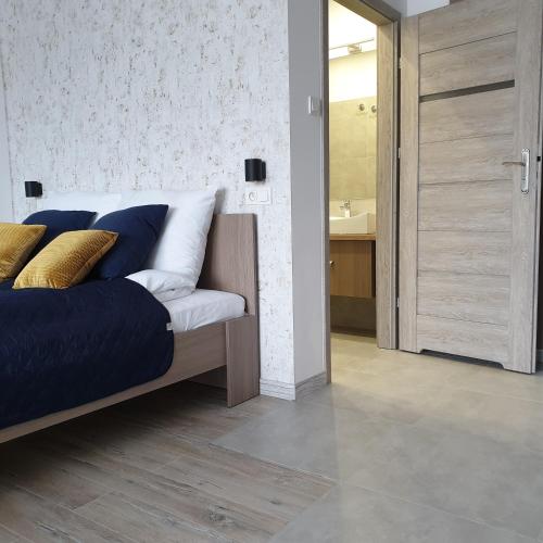 a bedroom with a bed and a bathroom with a sink at Q Apart Meta -1, 2 lub 3-pokojowe, klimatyzowane apartamenty przy Manufakturze z garażem lub parkingiem Gratis, FV in Łódź