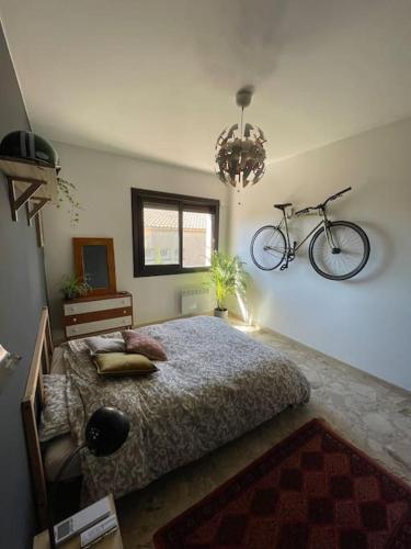 - une chambre avec un lit et un vélo sur le mur dans l'établissement Superbe appartement climatisé - calme absolu, à Bandol