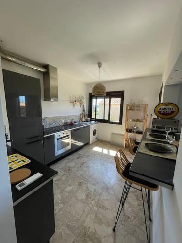 - une grande cuisine avec un comptoir et des chaises dans l'établissement Superbe appartement climatisé - calme absolu, à Bandol