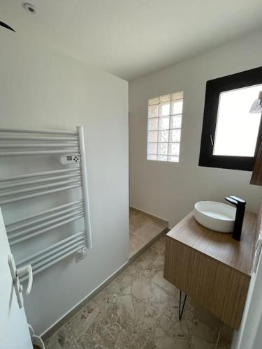 une salle de bain blanche avec un lavabo et une fenêtre dans l'établissement Superbe appartement climatisé - calme absolu, à Bandol