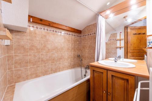 a bathroom with a tub and a sink and a bath tub at Les Belles d'Arly - Appt vue montagne in Praz-sur-Arly
