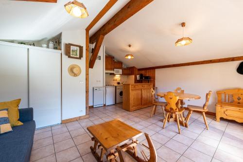 une cuisine et un salon avec une table et un canapé dans l'établissement Les Belles d'Arly - Appt vue montagne, à Praz-sur-Arly