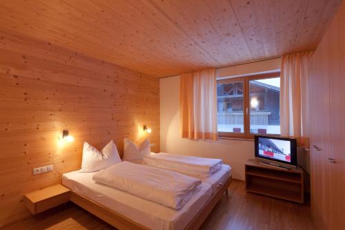 1 dormitorio con 1 cama y TV en Hotel Gasthof Wälderhof, en Lingenau