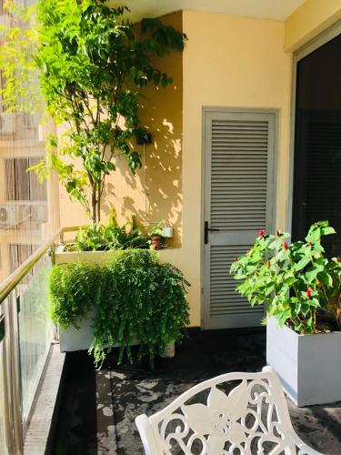 a white bench sitting on a balcony with plants at Luxurious Fully Furnished Apartment for Rent at 2000 Plaza, Colombo in Sri Jayewardenepura Kotte