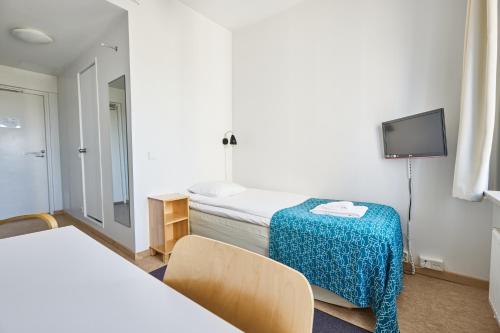 a hotel room with two beds and a television at Töölö Towers in Helsinki