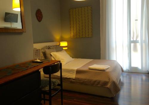 a bedroom with a bed and a desk with a chair at Ay Home B&B in Bologna