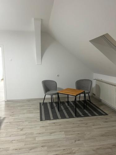 two chairs and a table in an empty room at Sleep and Fly room's by Dado & Lela in Velika Gorica
