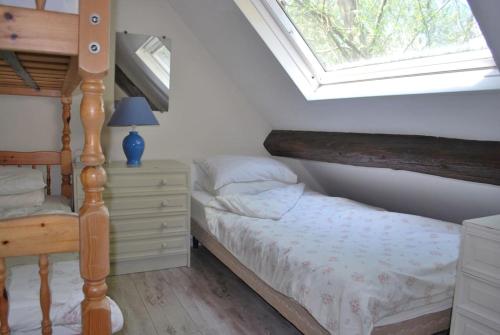 a bedroom with a bed and a window at Les Roses, avec piscine, tennis et lac privatif in Guerquesalles